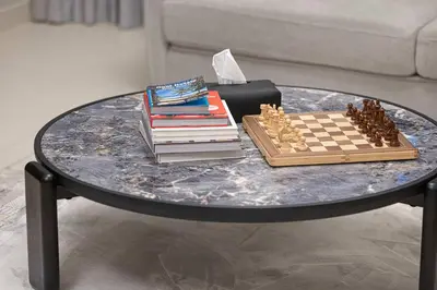 a table with books and a chess board on it at Two Identical Apartments - Same Building in Dubai