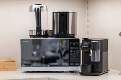 a microwave with a coffee maker on top of it at Two Identical Apartments - Same Building in Dubai