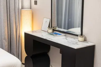 a desk in a hotel room with a mirror and a laptop at Two Identical Apartments - Same Building in Dubai