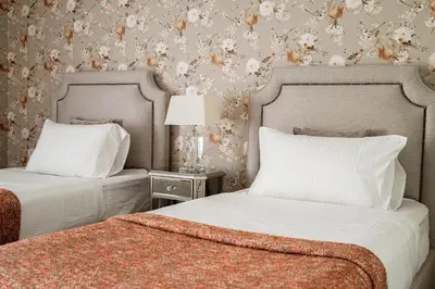 two beds in a bedroom with flowers on the wall at Penthouse four bedroom with two large chillout terraces in Dubai