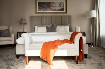a bedroom with a bed with an orange blanket on a chair at Penthouse four bedroom with two large chillout terraces in Dubai