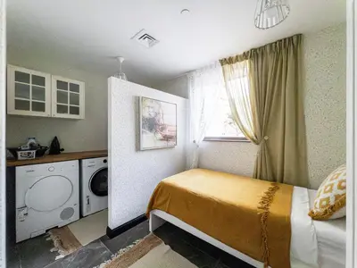 a small bedroom with a bed and a washing machine at Penthouse four bedroom with two large chillout terraces in Dubai