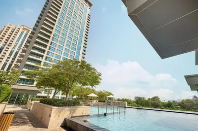a swimming pool in front of a tall building at Spacious Apartment with Excellent Facilities in Dubai