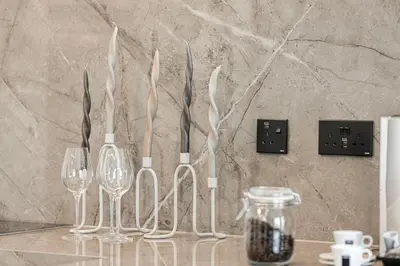 a group of wine glasses and wine bottles on a counter at Spacious Apartment with Excellent Facilities in Dubai