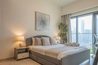 a bedroom with a bed with a large window at Stunning Burj Khalifa View! Steps to Dubai Mall in Dubai