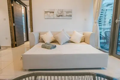 a white couch in a living room with a window at Dubai Marina Skyline with Sunset and Sunrise View in Dubai