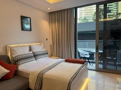 a bedroom with a bed and a balcony with a table at The Sterling 4 sleep with AC parking and pool in Dubai
