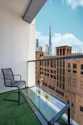 a balcony with a glass table and a chair on a building at Sanctuary Stays - Premium 1BR - Burj Khalifa Views - Near Dubai Mall in Dubai