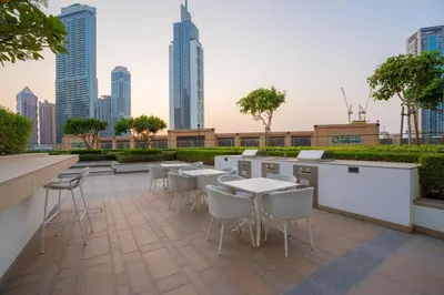 a rooftop patio with tables and chairs and a city skyline at Luxury 2BR at Burj Crown Sleeps 7 PS5 & 65-inch TV in Dubai