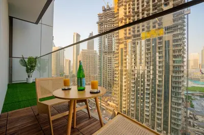 a table and chairs on a balcony with a view of a city at Luxury 2BR at Burj Crown Sleeps 7 PS5 & 65-inch TV in Dubai