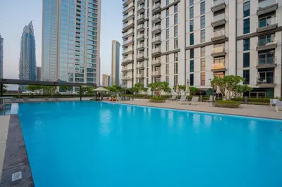 a large blue swimming pool in a city with tall buildings at Luxury 2BR at Burj Crown Sleeps 7 PS5 & 65-inch TV in Dubai