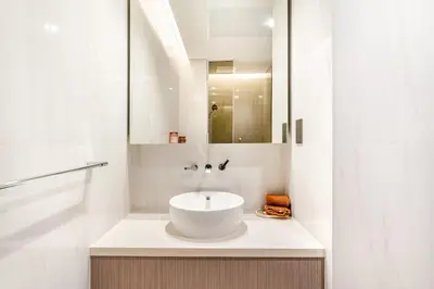 a white bathroom with a sink and a mirror at Medina Studio Burj Khalifa View in Dubai