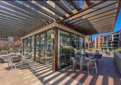 an outdoor patio with tables and chairs and glass at Medina Studio Burj Khalifa View in Dubai