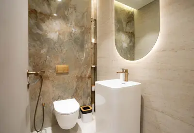 a bathroom with a toilet and a sink and a mirror at Designer 1BR Apt with Modern and Airy Layout in Dubai