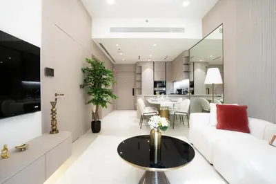 a living room with a white couch and a table at Designer 1BR Apt with Modern and Airy Layout in Dubai