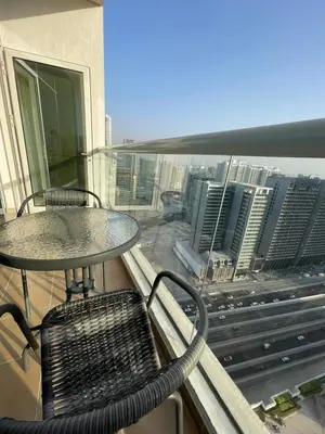 a table and chairs on a balcony with a view of a city at Spacious Modern Studio In downtown in Dubai