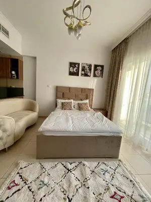 a bedroom with a bed and a chandelier at Spacious Modern Studio In downtown in Dubai