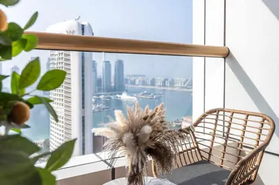 a chair in front of a window with a view of the city at Luxury Renovated 1BR w Full Sea View in Dubai