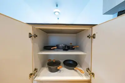 a cupboard with pots and pans in it at harborfront elegance dubai in Dubai