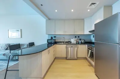 a kitchen with a counter top and a refrigerator at harborfront elegance dubai in Dubai