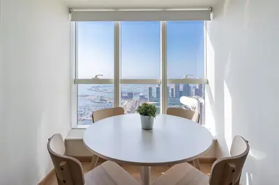 a white table and chairs in a room with a large window at harborfront elegance dubai in Dubai