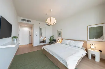 a bedroom with a large bed and a flat screen tv at harborfront elegance dubai in Dubai
