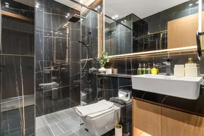 a bathroom with a toilet and a sink and a shower at VayK - Modern 2BD Retreat with Private Pool in JVC in Dubai