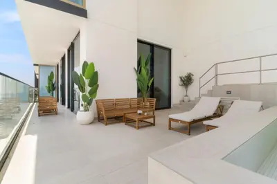 a balcony with chairs and tables on a building at VayK - Modern 2BD Retreat with Private Pool in JVC in Dubai