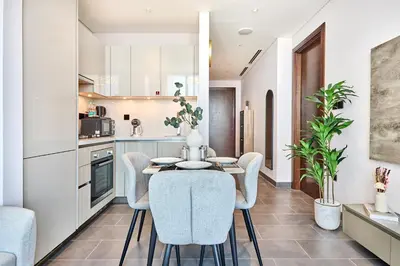 a kitchen and dining room with a table and chairs at STAY BY LATINEM Luxury 1BR Holiday Home CB 3107 Near Burj Khalifa in Dubai