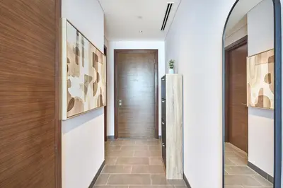 a hallway with a wooden door and a tile floor at STAY BY LATINEM Luxury 1BR Holiday Home CB 3107 Near Burj Khalifa in Dubai
