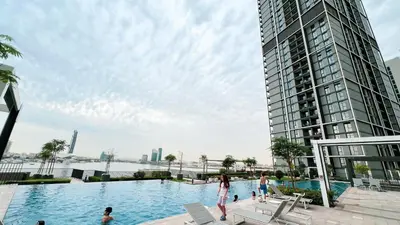 a swimming pool in front of a tall building at Luxury 2BR 34th Floor Burj Khalifa Sea Creek View in Dubai