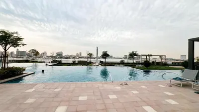a large swimming pool with a city in the background at Luxury 2BR 34th Floor Burj Khalifa Sea Creek View in Dubai