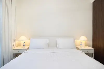a bedroom with a white bed with two lamps on tables at Luxury 2BR 34th Floor Burj Khalifa Sea Creek View in Dubai