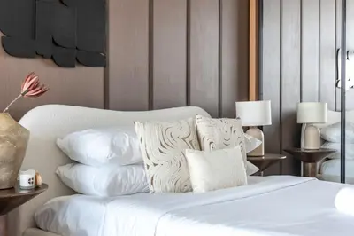 a bedroom with a bed with white sheets and pillows at GuestReady - Balcony with Jacuzzi | Canal View in Dubai