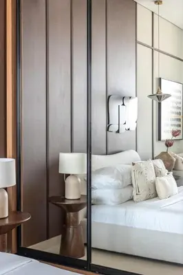 a bedroom with a bed with a mirrored wall at GuestReady - Balcony with Jacuzzi | Canal View in Dubai