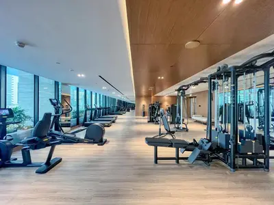 a gym with a row of treadmills and machines at GuestReady - Balcony with Jacuzzi | Canal View in Dubai