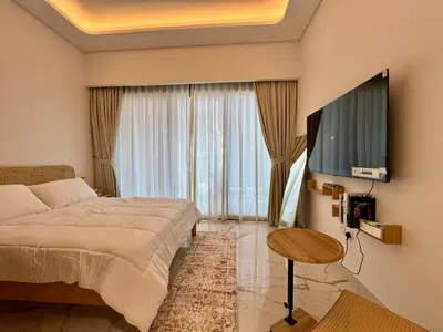a bedroom with a bed and a large window at Stylish Studio In Azizi Riviera 59 in Dubai