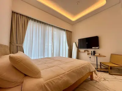 a hotel room with a bed and a large window at Stylish Studio In Azizi Riviera 59 in Dubai