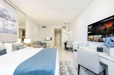 a bedroom with a large bed and a living room at Stunning Studio facing Burj Khalifa in Dubai