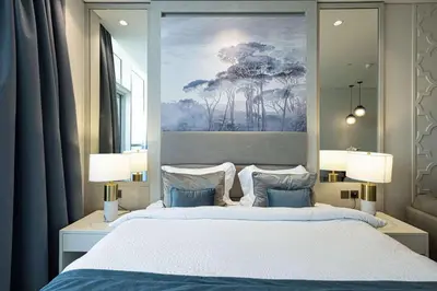 a bedroom with a large bed with a painting on the wall at Stunning Studio facing Burj Khalifa in Dubai