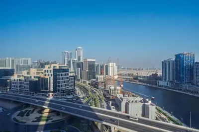 a view of a city with a bridge and buildings at Cozy Waterfront Studio Pool, Gym, Parking in Dubai
