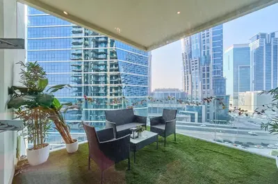 a living room with chairs and a large window at FAM Living Contemporary 1BR Apartment Urban Oasis in Dubai