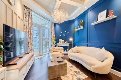 a blue living room with a couch and a tv at FAM Living Contemporary 1BR Apartment Urban Oasis in Dubai