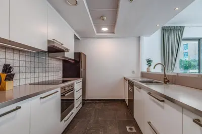 a kitchen with white cabinets and a sink at Residences 1 Tower 5 E2 - 2BR Apartment - Allsopp & Allsopp in Dubai