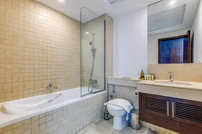 a bathroom with a tub and a toilet and a sink at Residences 1 Tower 5 E2 - 2BR Apartment - Allsopp & Allsopp in Dubai