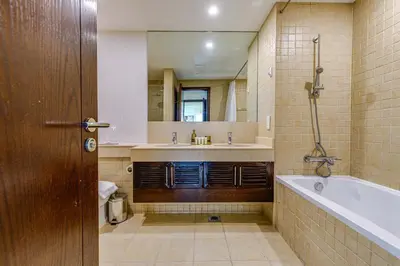 a bathroom with a tub and a sink and a mirror at Residences 1 Tower 5 E2 - 2BR Apartment - Allsopp & Allsopp in Dubai