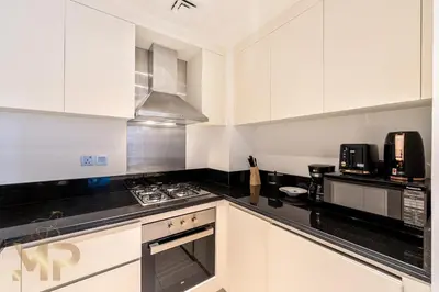 a kitchen with white cabinets and black counter tops at Marcopolo - Experience modern living in Business Bay Dubai in Dubai