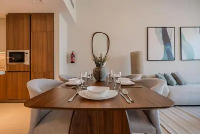 a dining room with a table and a couch at TRPS - Imperial Avenue, Downtown - Burj Khalifa View, Brand New, Amazing Facilities in Dubai