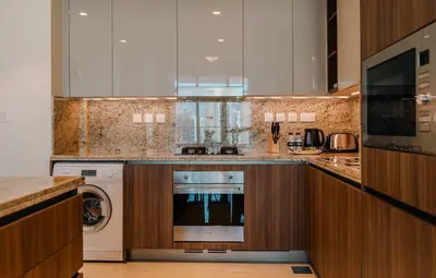 a kitchen with a washer and dryer in it at TRPS - Imperial Avenue, Downtown - Burj Khalifa View, Brand New, Amazing Facilities in Dubai