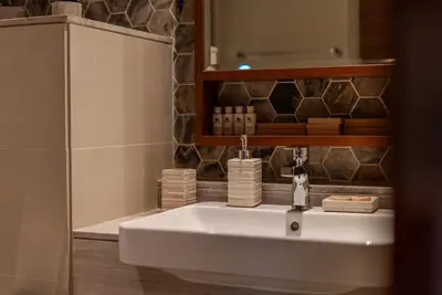 a bathroom with a white sink and a mirror at TRPS - Imperial Avenue, Downtown - Burj Khalifa View, Brand New, Amazing Facilities in Dubai